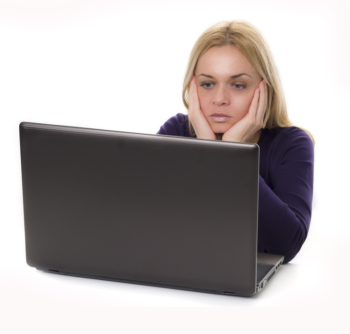 Foto einer Frau vor dem Laptop in nachdenklicher Körperhaltung